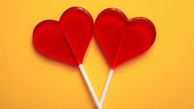 Two lollipops, shaped as red hearts