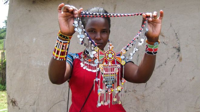 Женщина масаи демонстрирует свою бисероплетение в общине Амбосели