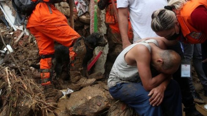 Un hombre siendo confortado por una rescatista