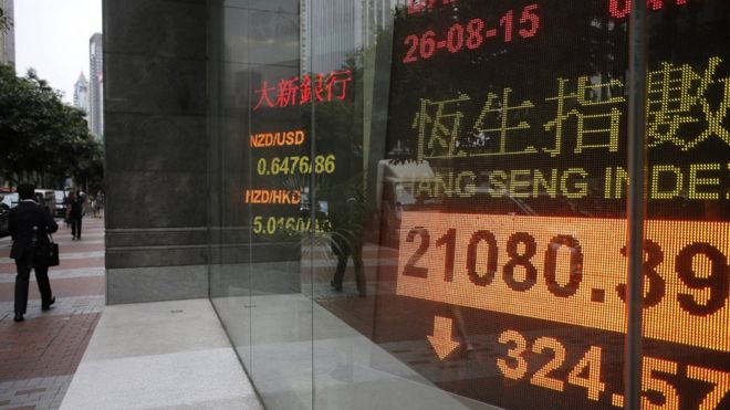 Электронная доска, показывающая индекс акций Гонконга за пределами местного банка в Гонконге