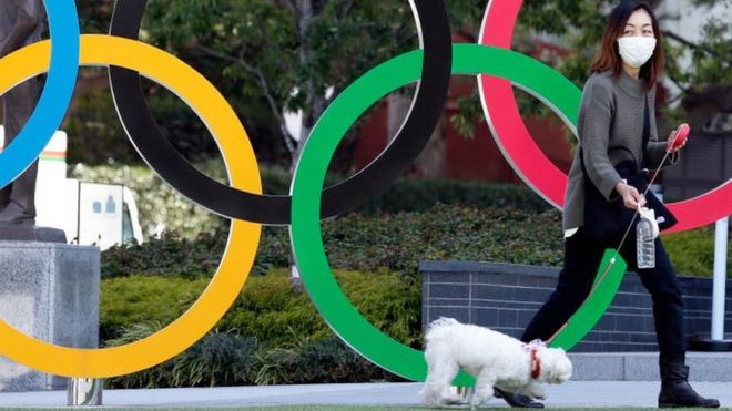 Woman with dog in front of Olympic rings