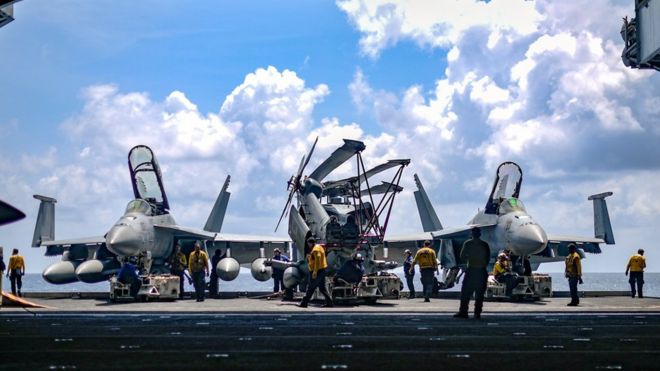 Thủy thủ Hải quân Hoa Kỳ di chuyển máy bay từ thang máy vào khoang chứa máy bay của tàu sân bay USS Theodore Roosevelt ở Biển Đông hôm 8/4.