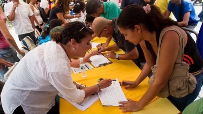 Люди участвуют в мероприятии, организованном венесуэльской оппозицией и собирающем подписи в рамках процесса проведения референдума по смещению президента Венесуэлы Николаса Мадуро в Каракасе, Венесуэла, 27 апреля 2016 года.