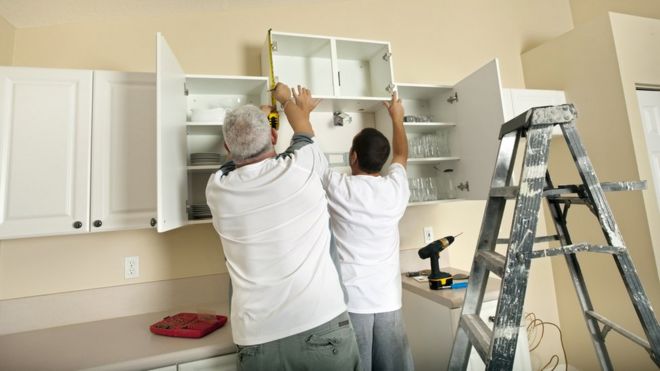 строители устанавливают кухонные шкафы