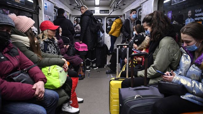 Pessoas carregam malas e outros pertences no metrô de Kiev na manhã de 24 de fevereiro