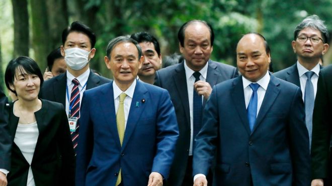 Thủ tướng Nhật Bản Yoshihide Suga (thứ 3) và người đồng cấp Việt Nam Nguyễn Xuân Phúc (thứ 2) thăm Nhà sàn của cố Chủ tịch Hồ Chí Minh tại Hà Nội ngày 19/10/2020