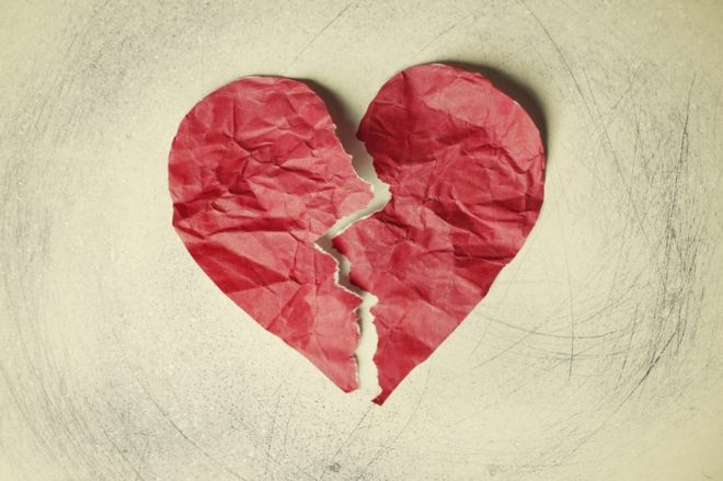 A crumpled paper heart, torn in half