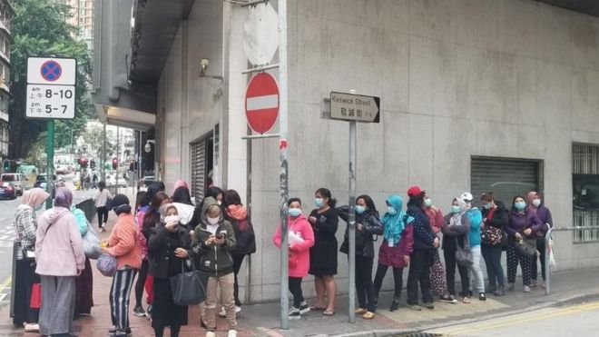 Граждане Индонезии выстраиваются в очередь за бесплатными масками у генерального консульства Индонезии в Гонконге.