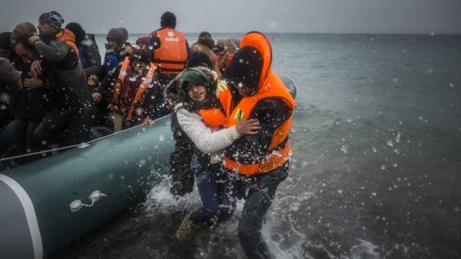 Беженцы и мигранты высадились на пляже после пересечения части Эгейского моря из Турции на греческий остров Лесбос 3 января 2016 года