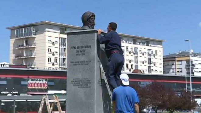 Рабочий поднимается по лестнице, чтобы снять бюст Юрия Гагарина с его постамента