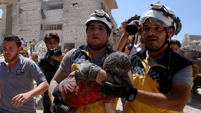 Members of the Syrian civil defence, known as the White Helmets, pull out an injured but alive child from under the rubble following a Russian air strike on Maaret al-Numan in Syria's northwestern Idlib province on July 22, 2019