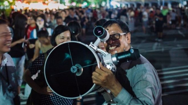 Люди установили телескопы, чтобы засвидетельствовать редкое лунное затмение около 27 в Тайбэе, Тайвань