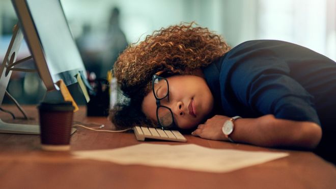 Una trabajadora estadounidense dormida en su escritorio.