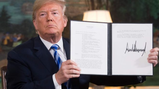 На этом фото, сделанном 8 мая 2018 года, президент США Дональд Трамп подписывает документ о восстановлении санкций против Ирана