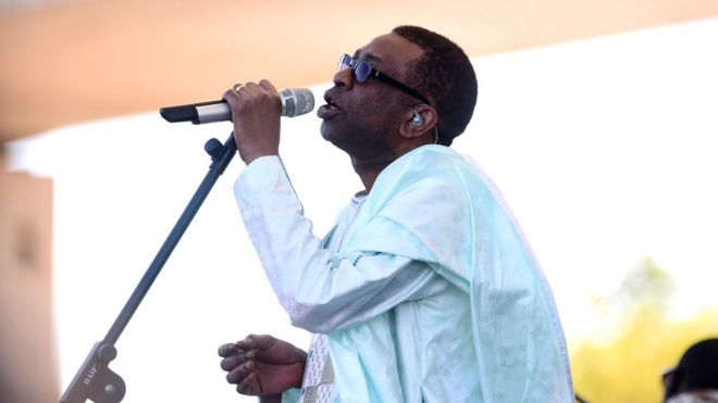 Сенегальский певец Юссу Ндур выступает во время инаугурации моста Фарафенни 21 января 2019 года в Фарафенни