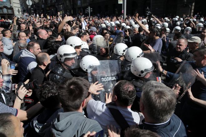 Протестующие стоят перед ОМОНом возле резиденции президента Сербии Александра Вучича в Белграде. Фото: 17 марта 2019 года