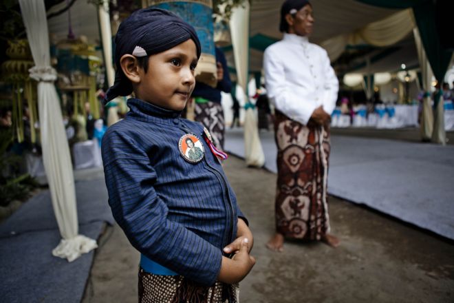 Йогья мальчик носит предвыборную агитацию с изображением квинсов для сената.