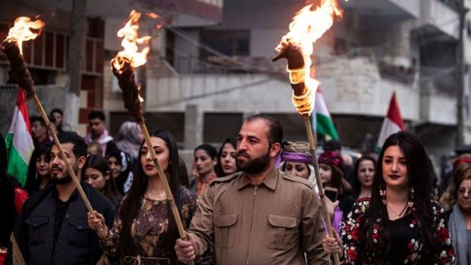 أكراد يحملون المشاعل في ليلة نوروز، في مدينة القامشلي، شمال شرقي سوريا