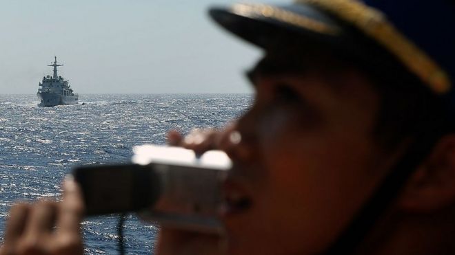 This picture taken from a Vietnam Coast Guard ship on May 14, 2014 shows a Vietnamese Coast Guard officer taking picture of a China Coast Guard ship