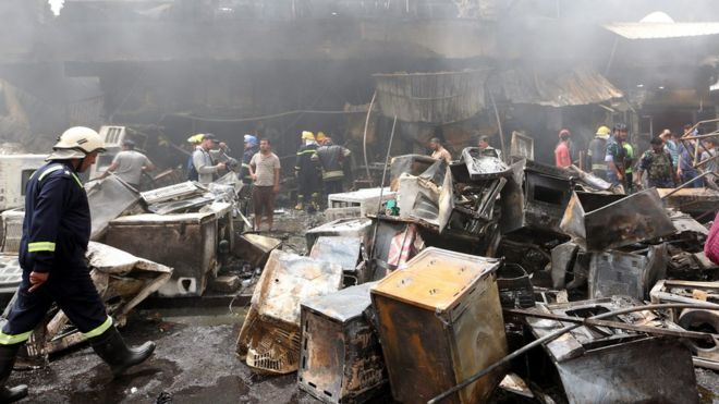 Иракские пожарные проверяют место взрыва автомобильной бомбы в Багдаде 9 июня