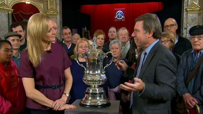 BBC Sport's Gabby Logan and Antiques Roadshow expert Alastair Dickenson with the FA Cup trophy