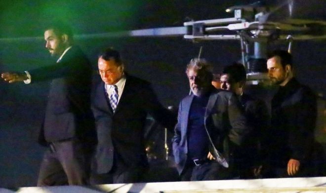 Лула покидает полицейский вертолет после прибытия в штаб-квартиру Федеральной полиции в Куритибе