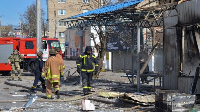 Rescuers work at a bus stop which was hit during a rocket attack in Kherson