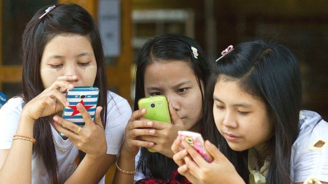 Young women staring at mobile phones