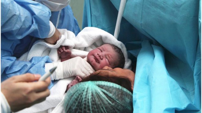 Mujer y su recién nacido en un paritorio.