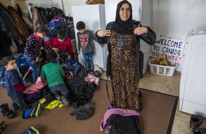 Сирийская беженка Sawsan Al Jasem наблюдает за тем, как ее дети готовятся выйти на улицу в своем временном доме в Пиктоне, Онтарио, Канада, в среду, 20 января 2016 года.