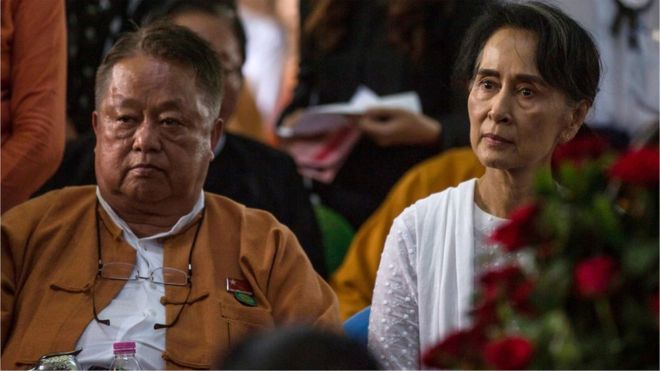 Myanmar's State Counselor Aung San Suu Kyi (R) and Win Htein, chief executive committee members of the National League for Democracy (NLD), attend the funeral service for the party's former chairman Aung Shwe in Yangon on August 17, 2017.