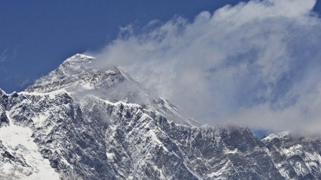 На этой фотографии, сделанной 20 апреля 2015 года, показан вид на гору Эверест (С-вершина), возвышающуюся над массивом Нупсе-Лохце (на переднем плане) из деревни Тембуче в регионе Кхумбу на северо-востоке Непала.