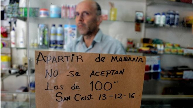Вход в магазин в приграничном городе Сан-Кристобаль в Венесуэле предупреждает, что купюры в 100 боливаров не будут приниматься со вторника