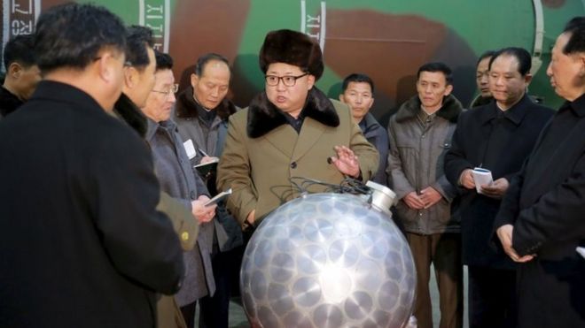 Северокорейский лидер Ким Чен Ын беседует с учеными рядом с тем, что, по словам Севера, является моделью миниатюрной водородной бомбы (9 марта 2016 года)