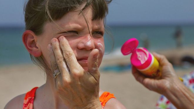 ребенок с солнцезащитным кремом на лице