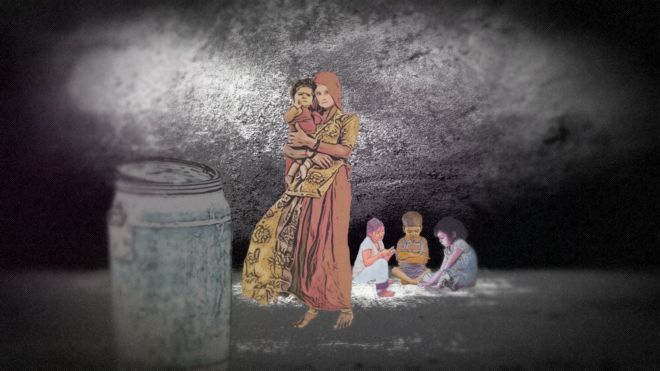 Женщина в сари держит ребенка с тремя детьми, сидящими и играющими на полу.