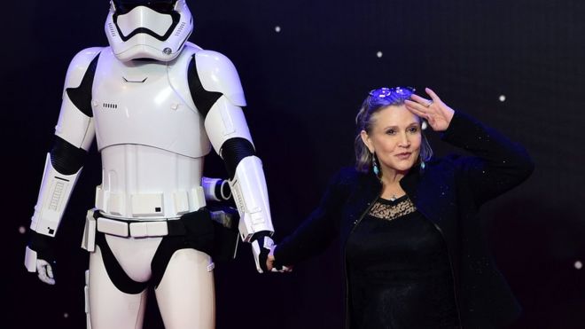 US actress Carrie Fisher (R) posing with a storm trooper as she attends the opening of the European Premiere of "Star Wars: The Force Awakens" in central London on 16 December, 2015
