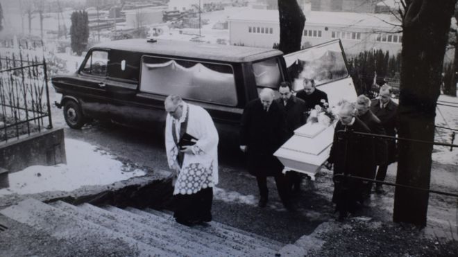Полицейская фотография похорон показывает священника на кладбище Моллендаль, а шесть полицейских несут белый гроб с телом женщины Исдала