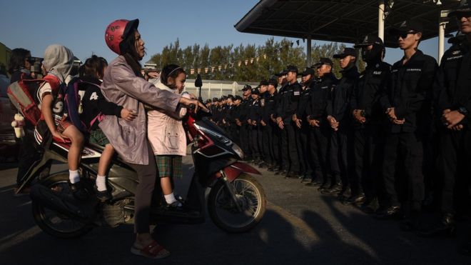 A woman trying to take her children to school is refused passage due to a police blockade in front of Wat Dhammakaya temple near Bangkok 16 February 2017