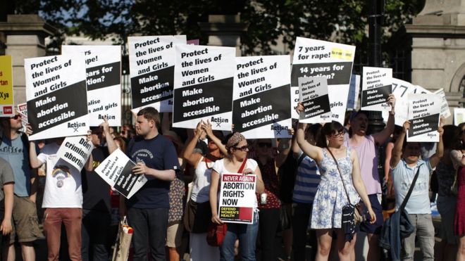 Сторонники «за выбор» держат плакаты перед воротами здания ирландского парламента в Дублине 10 июля 2013 года во время демонстрации перед голосованием, чтобы ввести аборт в ограниченных случаях, когда жизнь матери находится под угрозой.