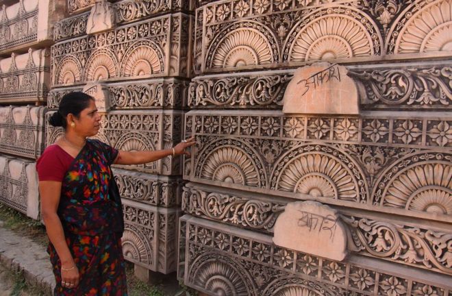 Индуистка смотрит на каменные плиты, предназначенные для строительства индуистского храма, в мастерской в ??Айодхье в 2012 году.