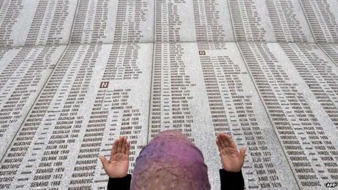 На этом снимке 2008 года боснийская мусульманка молится у мемориальной стены с именами жертв резни в Сребренице