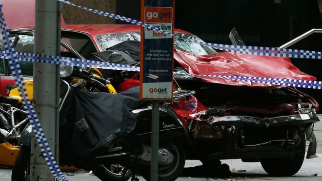 Обломки машины видны как полиция, оцепленная возле торгового центра на улице Бурк, после того, как машина ударила пешеходов в центре Мельбурна, Австралия, 20 января 2017 г.