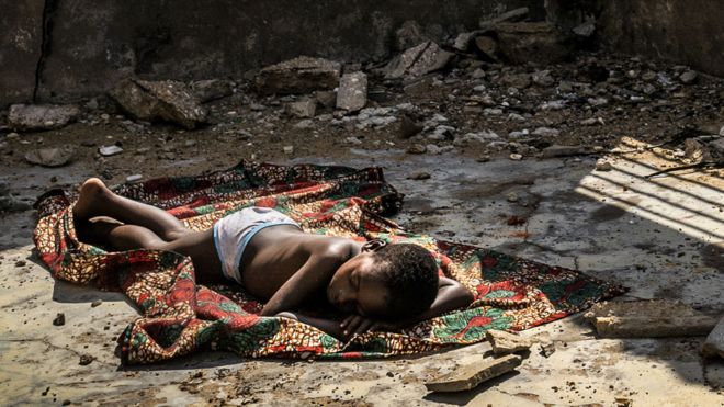 Un niño duerme dentro de una casa en ruinas en una playa en Ghana en 2019