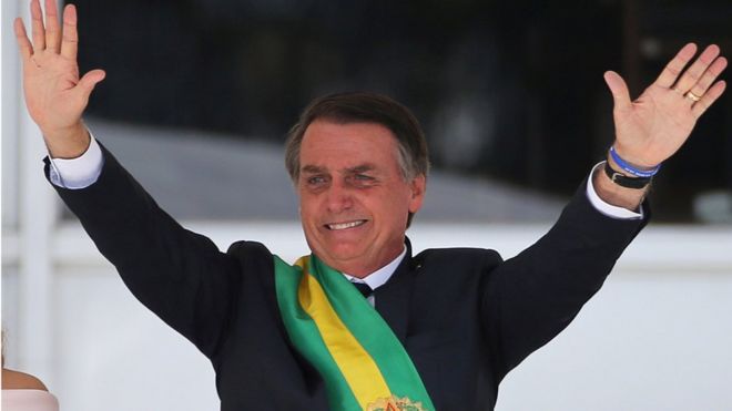 Президент Бразилии Жаир Больсонаро поднял руки вверх на своей инаугурации в январе 2019 года