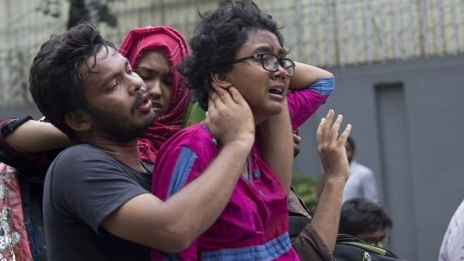 Люди помогают раненому студенту в университете Дакки