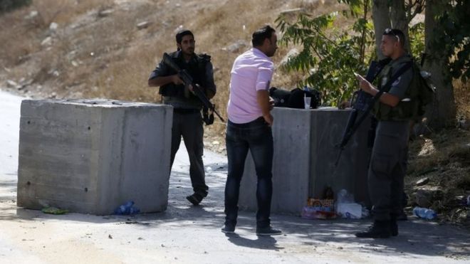 Израильские пограничники проверяют документы палестинца на блокпосту, установленном в Восточном Иерусалиме 15 октября 2015 года