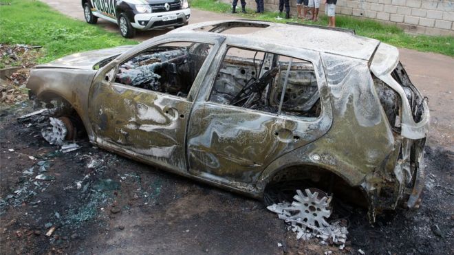 Автомобиль, брошенный и сожженный, как считается, принадлежит виновникам стрельбы в клубе в Форталезе, Бразилия, 27 января 2018 года.