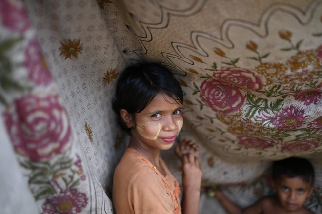 Девушка-беженка из рохингья позирует фотографу, когда она носит пасту Танака в лагере Шамлапур на базаре Кокса, Бангладеш