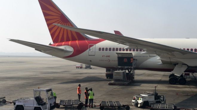 Работники аэропорта загружают самолет Air India в главном терминале международного аэропорта имени Индиры Ганди в Нью-Дели 25 ноября 2014 года.